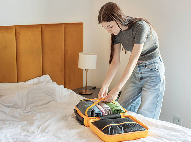 istock Woman packing suitcase on bed preparing for trip 2249490891