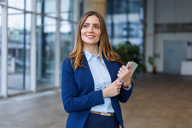 istock Confident businesswoman holding tablet looking away thinking future 2249493034