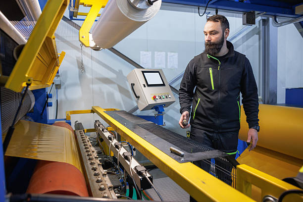 istock Industrial machine operator inspecting large roll line in modern factory setting 2249493262