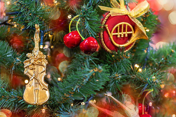 Christmas tree decorated with musical instruments, violin and cherries. Copy space.
