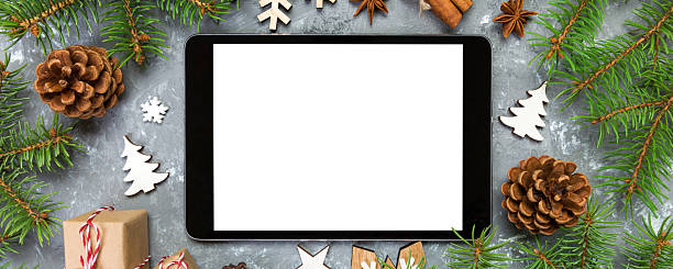 istock Digital tablet mock up with rustic Christmas gray cement background decorations for app presentation. top view with copy space 2249495354