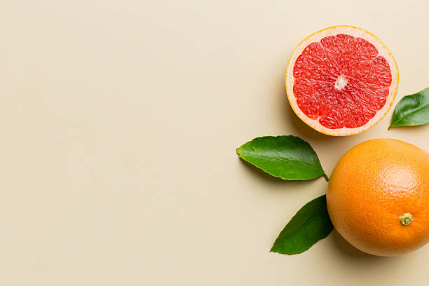 istock fresh Fruit grapefruit with Juicy grapefruit slices on colored background. Top view. Copy Space. creative summer concept. Half of citrus in minimal flat lay with copy space 2249495384