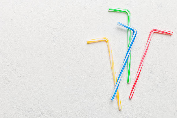 istock Drinking straws for party on Colored background. Top view of colorful plastic disposable straws for summer cocktails. different straws for juice with copy space 2249495583