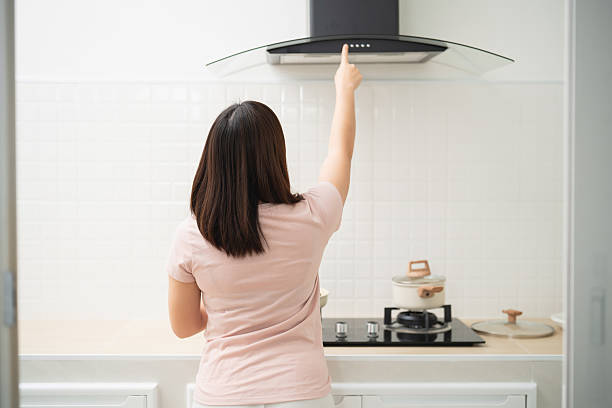 istock Woman Adjusting Range Hood in Modern Kitchen, Cooking Area, Home Appliances, Culinary Preparation, Domestic Environment, Indoor Cooking Space 2249498517