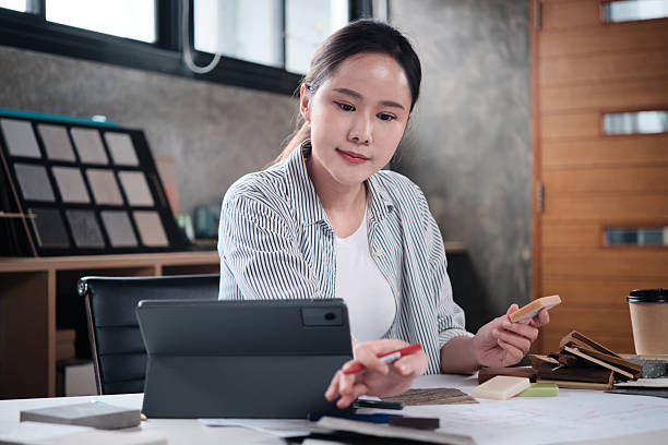 istock Female Asian architect designs works with choosing materials in studio. 2249500497