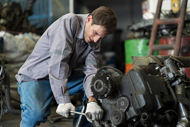 istock Male auto mechanic working, using socket wrench tighten old engine nuts for separate parts in warehouse auto spare parts. Car service technician check and repair car engine in garage 2249500712