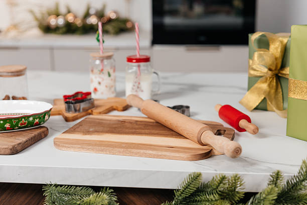 istock Festive Christmas kitchen setup with wooden rolling pins, baking tools, cookie cutters, milk jars, and holiday decorations on a white countertop 2249501080