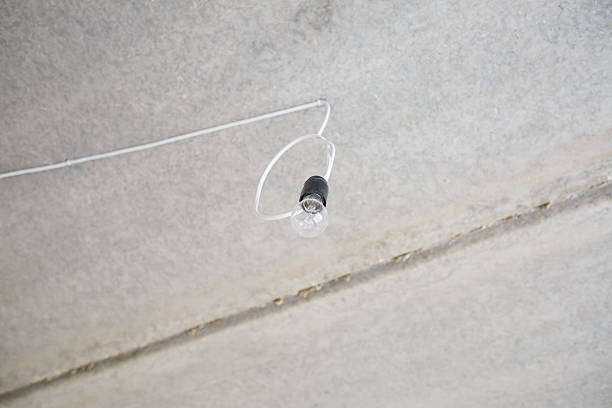 Light bulb on the ceiling. Lonely light bulb and wire sticking out of the ceiling during a repair