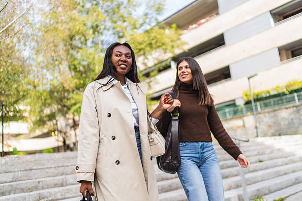 istock Two diverse friends walking up city stairs 2249503672