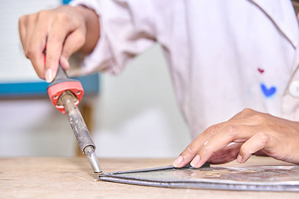 istock Craftsperson soldering stained glass using a craft tool 2249504426