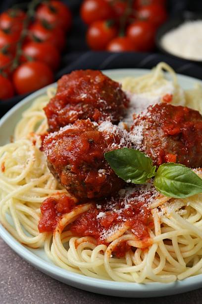 istock Delicious pasta with meatballs, basil and cheese on brown textured table, closeup 2249505630