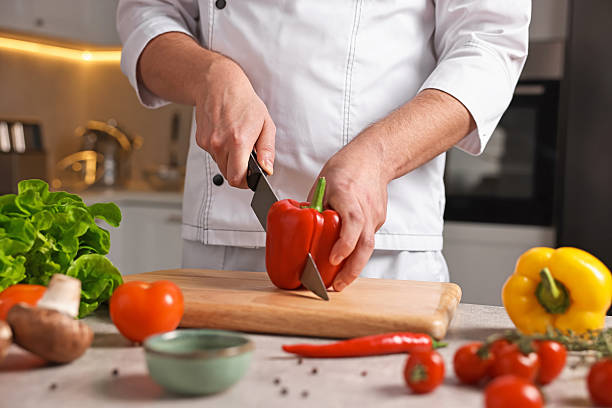istock Professional chef cutting bell pepper at table in kitchen, closeup 2249506097