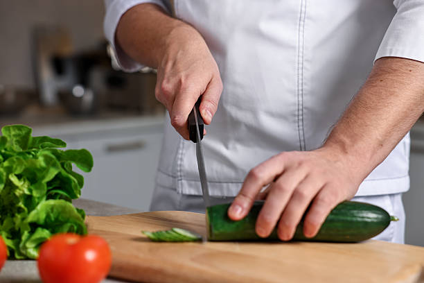 istock Professional chef cutting zucchini at table in kitchen, closeup 2249506125