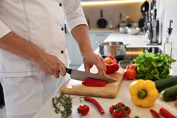 istock Professional chef cutting bell pepper at counter in kitchen, closeup 2249506155