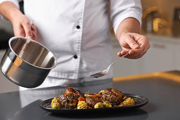 istock Professional chef adding sauce to delicious dish at table indoors, closeup 2249506170