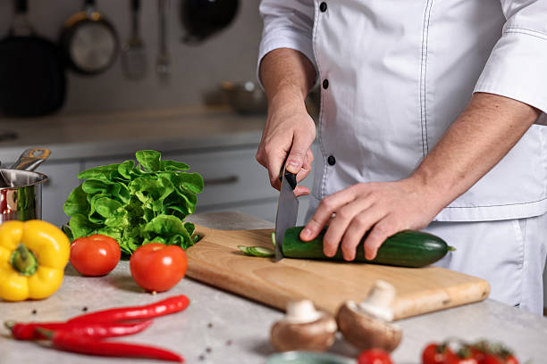 istock Professional chef cutting zucchini at table in kitchen, closeup 2249506173