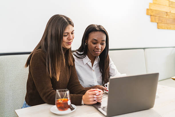 istock Two diverse women working on laptop in cafe 2249506299