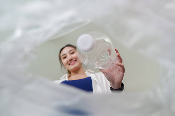 istock Recycling perspective. View from inside a trash bag as a woman drops a plastic bottle. 2249509122