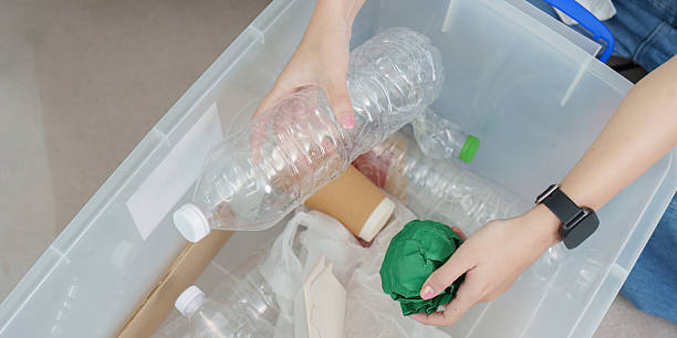 istock Recycling. Woman sorting plastic bottles in a clear recycling bin. 2249509185