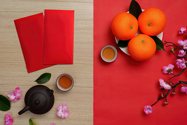 istock Chinese New Year festive arrangement with red envelopes, oranges, and tea 2249509623