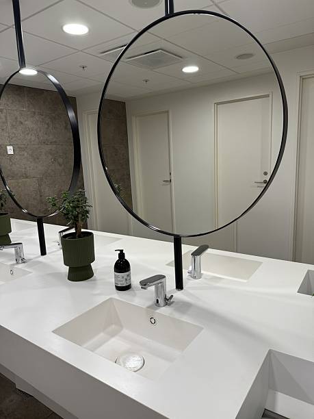 istock Elegant Luxury Hotel Restroom with Round Mirrors and Stone Interior 2249509687