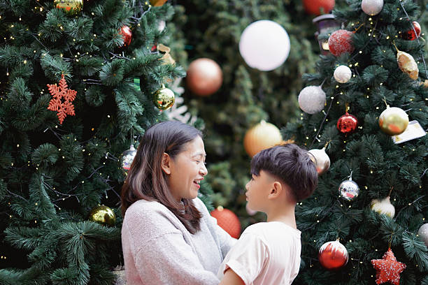 istock Mother and son hugging in front of a Christmas tree 2249509917