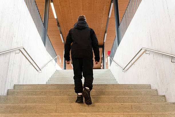 istock Man walking upstairs toward the light 2249512082