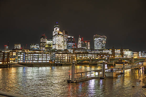 Millennium Bridge, London, England, United Kingdom, Europe - November 5th 2025: London’s skyline is in constant development as modern high-rise buildings rise up, and at night the illuminated cityscape reflects in the waters of the River Thames.