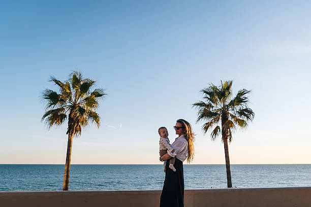 istock Mother holds baby son on seaside 2249517440