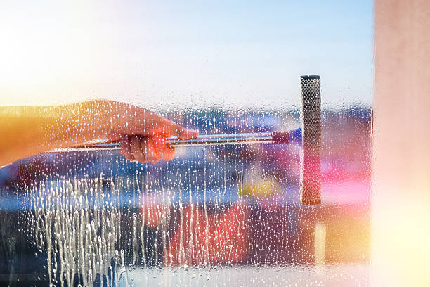 istock Window cleaning brush. Large window in a multi-storey building, cleaning service. Window cleaning in high-rise buildings, houses with a brush. Dust removal and glass washing. 2249518133