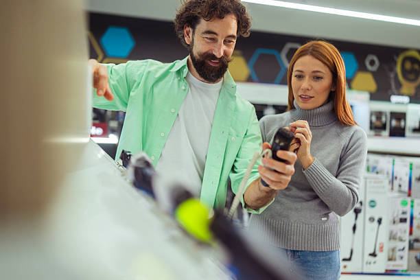 istock Loving couple examining electric shavers or beard trimmers on a display shelf in a electronics store 2249519953