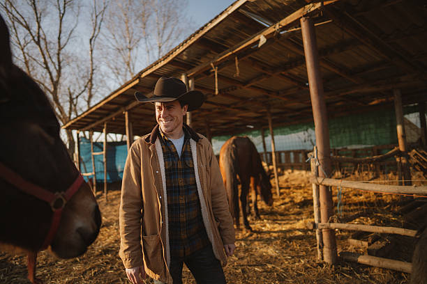 Photo of a mid adult men taking care of his animals at the horse ranch
