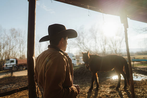 Photo of a mid adult men taking care of his animals at the horse ranch