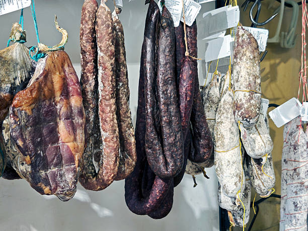 Local salamis at a shop in Norcia, a town and comune in the province of Perugia, Umbria, Italy. The area is known for its scenery and is also widely known for hunting, especially of the wild boar, and for sausages and ham made from wild boar and pork. In Italian, such products have been named after Norcia, and are known as norcineria.