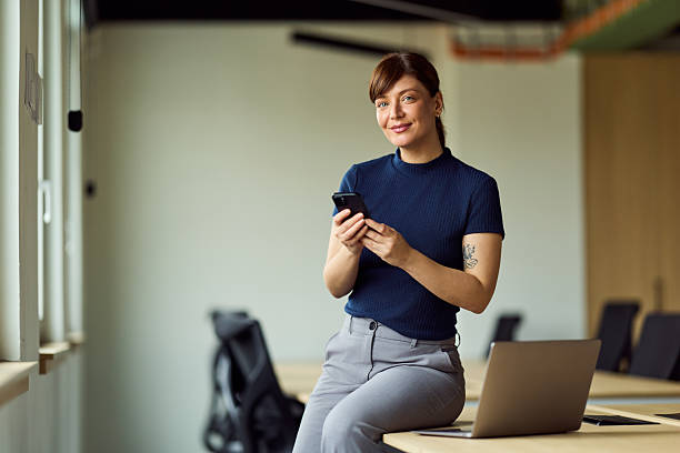 istock Confident Office Professional With Smartphone And Laptop In Modern Workspace 2249531178