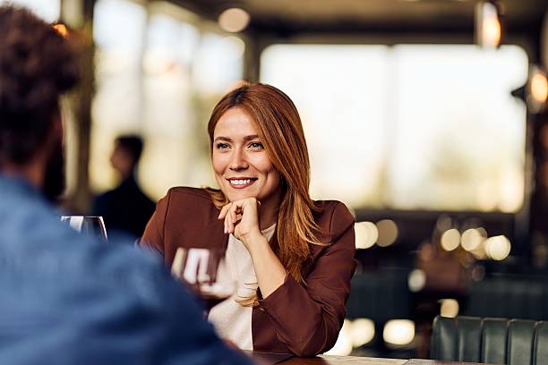 istock Smiling Woman Enjoying Casual Conversation at a Comfortable Restaurant Setting 2249531221