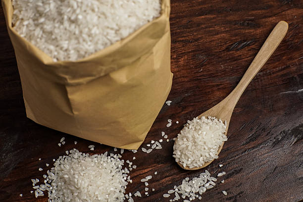 istock Rice Bag and Wooden Spoon on Rustic Table 2249531360