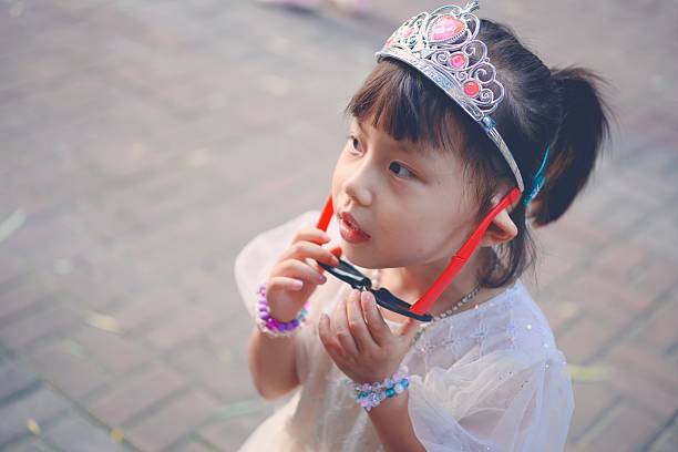 A little girl in a fairy outfit smiling while holding her wand
