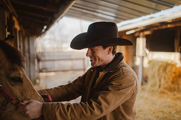 Photo of a mid adult men taking care of his animals at the horse ranch