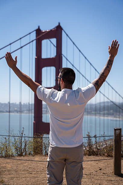 istock Man Raising Arms in Joy Facing Golden Gate Bridge 2249535253