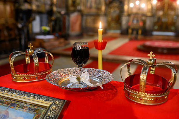 istock Two crowns, a cup of wine and a cross prepared for baptism 2249536455