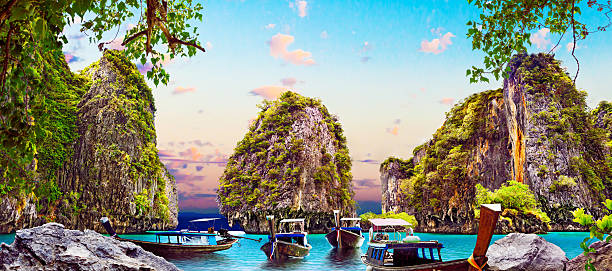 Thailand beach.Scenic paradise landscape.Resort and boats in sunset with mountains.