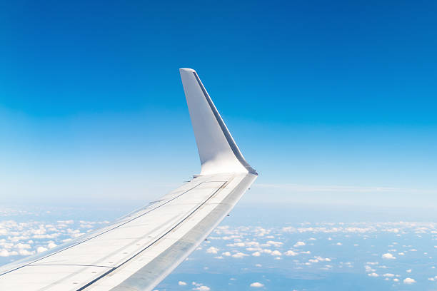 istock Airplane wing in blue sky with clouds on a clear day 2249540599