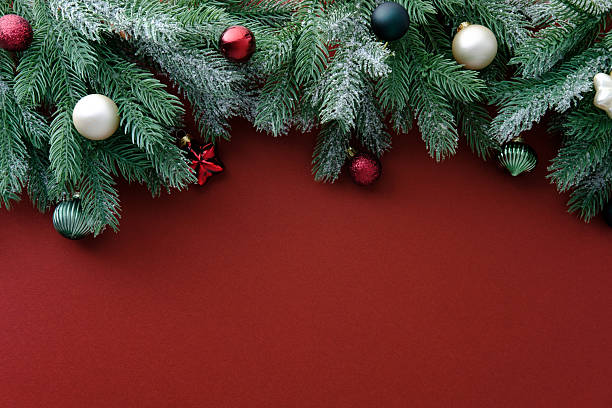 istock Christmas background with frosted pine branches and ornaments on a deep red surface. 2249542676