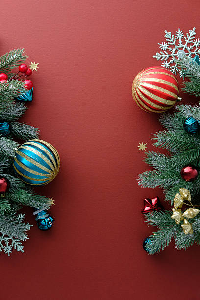 istock Vertical red Christmas background with snow-dusted pine branches and ornaments 2249542709