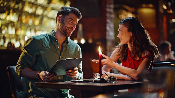 istock Happy pair looking menu at romantic date in bar closeup. Smiling couple talking 2249546366
