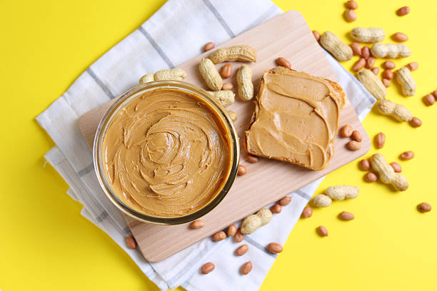 istock peanut butter and raw peanuts on a colored background 2249546587