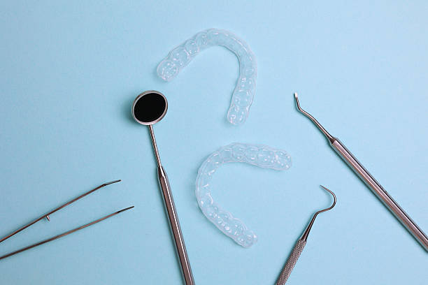 istock Transparent plastic aligners and dentist's tools on a colored background 2249546940