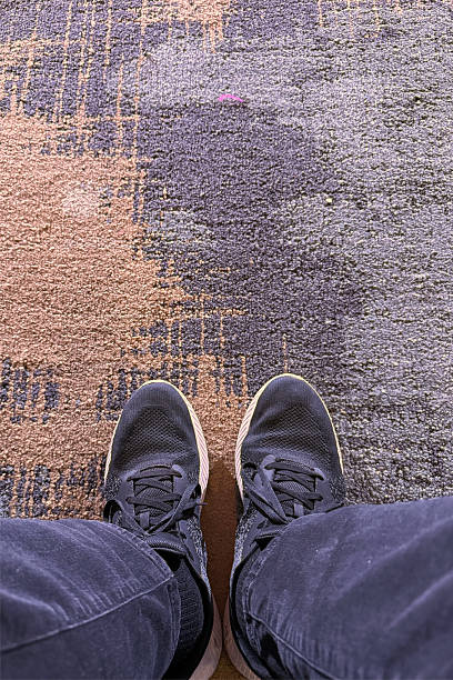 istock Shoes and legs on carpet 2249548207