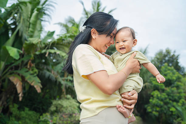 istock Adult Lifting Baby Outdoors in Natural Setting 2249548565
